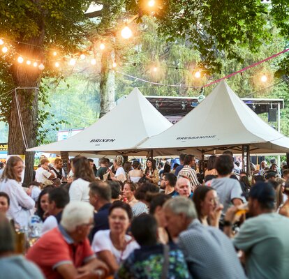 Two white Mastertent canopy tents set up to sell food at a festival.