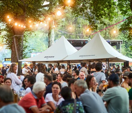 Two white Mastertent canopy tents set up to sell food at a festival.