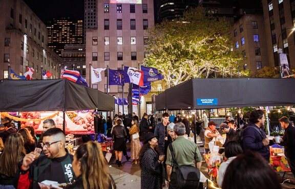 Event with presentation of various exhibitors with Mastertent modular system Square folding tents in black in front of a skyscraper backdrop with many visitors at the individual stands
