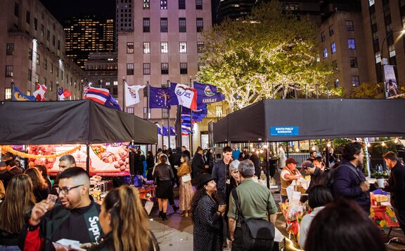 Manifestation avec présentation de différents exposants avec le système modulaire Mastertent Square Tentes pliantes en noir devant un décor de gratte-ciel avec de nombreux visiteurs sur les différents stands.