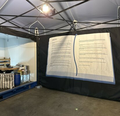 The interior of a 6x4 m folding gazebo can be seen. You can see its aluminium structure, the LED spotlights, the weights on the floor and the printed side wall. 