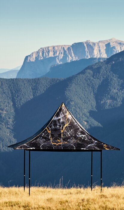 Gazebo pieghevole nero con 4 tettoie e stampa individuale sulla montagna Plose. Dietro si vede la catena montuosa.