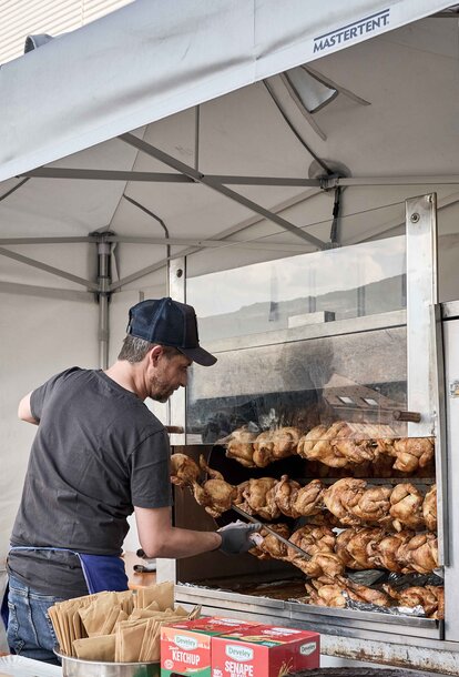 Cook cooks the spit at an event under a Mastertent fireproof and refractory kitchen gazebo