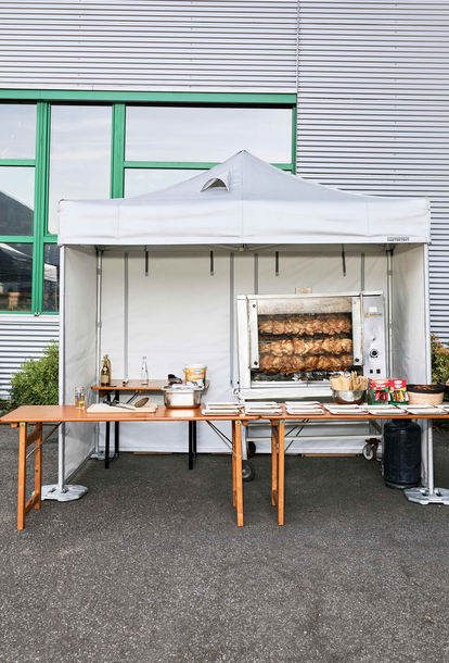 Spit-roasted chicken cooked under a Mastertent fireproof kitchen gazebo at an event 