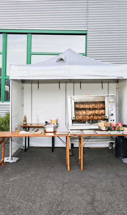 Hähnchen am Spieß, zubereitet unter einem feuerfesten Mastertent-Küchenzelt 