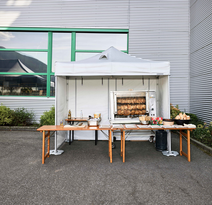 Spit-roasted chicken cooked under a Mastertent fireproof kitchen gazebo at an event 