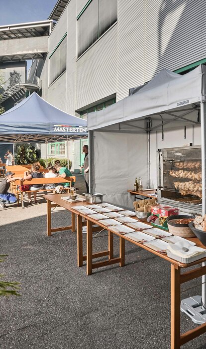 Spit-roasted chicken cooked under a Mastertent fireproof kitchen gazebo at an event 