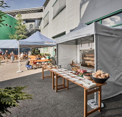 Spit-roasted chicken cooked under a Mastertent fireproof kitchen gazebo at an event 