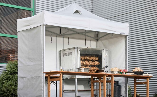  Hähnchen am Spieß, zubereitet unter einem feuerfesten Mastertent-Küchenzelt bei einer Veranstaltung 