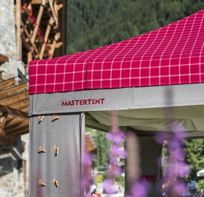 The kit Loden cover from the company MASTERTENT is located outside. On the cover are some leaves. 