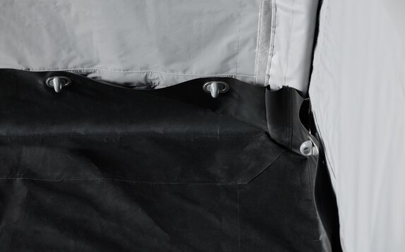 Con il kit Rescue le pareti laterali vengono collegate col pavimento. La donna sta inserendo il tubo di collegamento nel laccio. 