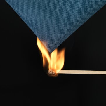 A burning match is used to ignite the blue fabric of the gazebo. 