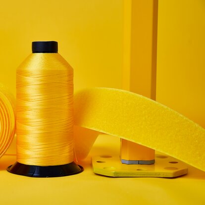 Yellow fabric, yellow velcro stip, yellow fabric roll and yellow structure for gazebos located side by side. 