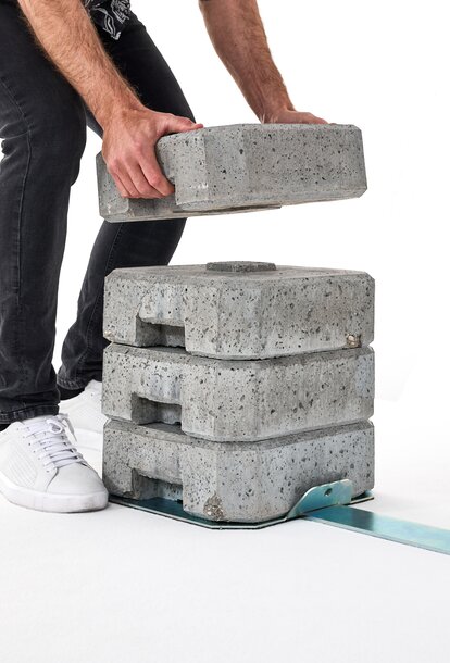 Montaje de un set de pesas de cemento con un soporte de hierro.