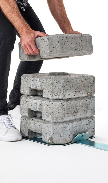 Montaje de un set de pesas de cemento con un soporte de hierro.