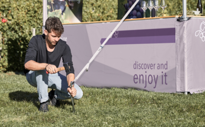 Fissaggio gazebo al suolo con picchetto e martello in un prato