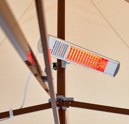 A mobile infrared heater mounted on the mast of a Mastertent canopy tent.