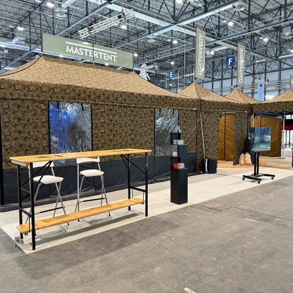 Militärzelte mit Tarnmuster auf Messe.